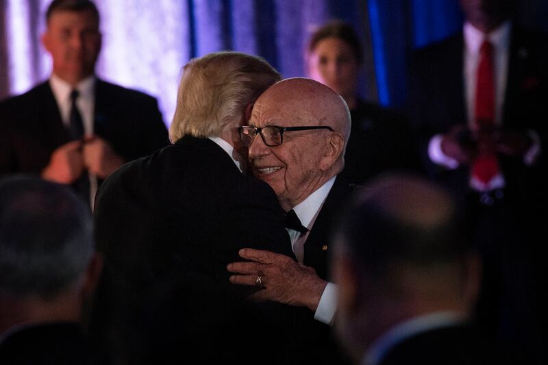 US President Donald Trump (L) is embraced by Rupert Murdoch, Executive Chairman of News Corp, during a dinner to commemorate the 75th anniversary of the Battle of the Coral Sea during WWII onboard the Intrepid Sea, Air and Space Museum May 4, 2017 in New York, New York. / AFP PHOTO / Brendan Smialowski        (Photo credit should read BRENDAN SMIALOWSKI/AFP via Getty Images)